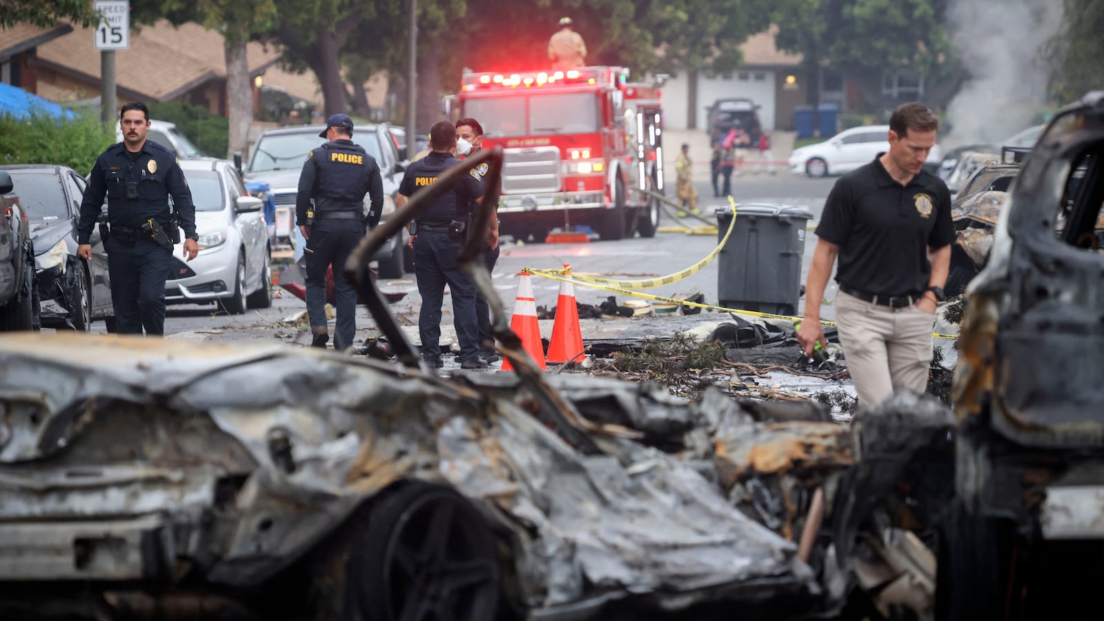 Investigators look through the site ehere a small plane crashed into San Diego, California.