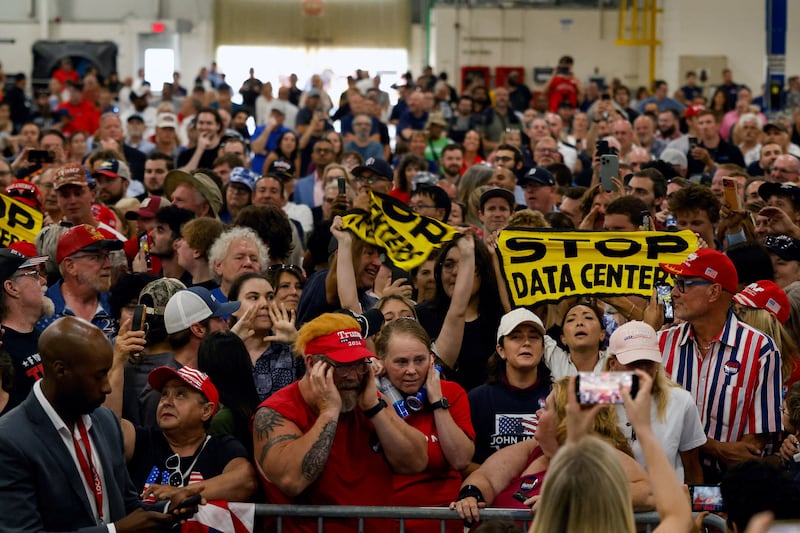 Protestors hold up 'Stop data centers' signs, on the day of U.S. President Donald Trump's speech at the General Motors Proving Ground, in Milford, Michigan, U.S. July 27, 2026.  REUTERS/Carlos Osorio     TPX IMAGES OF THE DAY