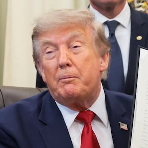 U.S. President Donald Trump holds up an executive order related to Utah protected lands after signing it in the Oval Office at the White House in Washington, D.C., U.S., July 13, 2026.