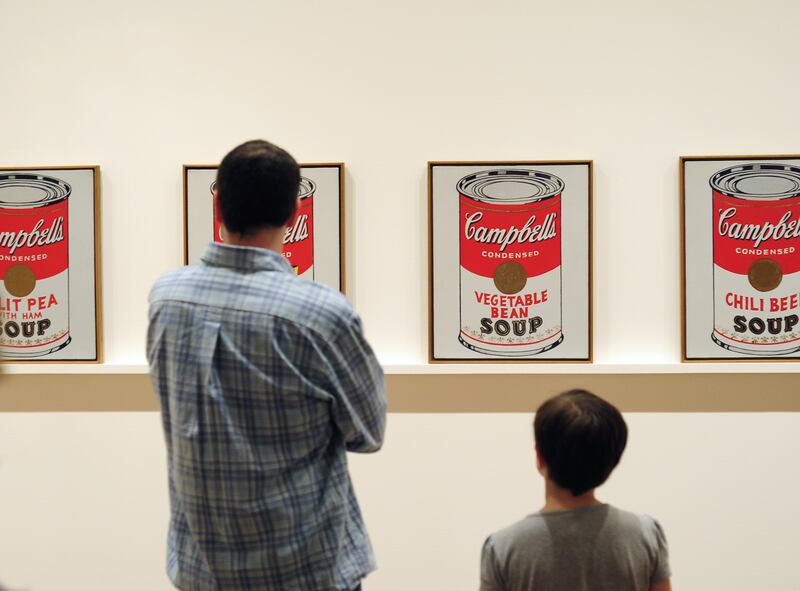 NEW YORK, NY - APRIL 26, 2015: Museum of Modern Art (MoMA) visitors look at silkscreen paintings depicting Campbell's Soup cans made by Andy Warhol in 1962 on display at the museum in Midtown Manhattan in New York City.