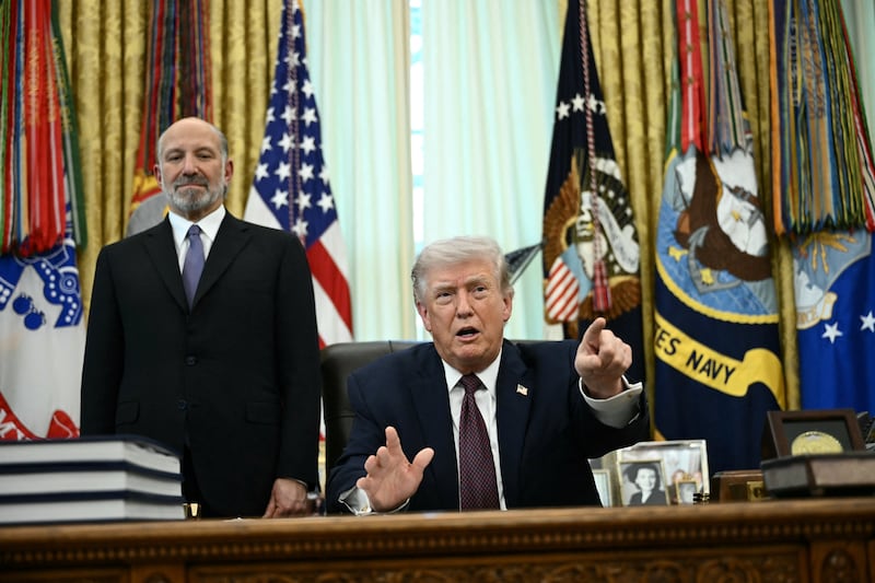 US President Donald Trump (R) speaks as Commerce Secretary Howard Lutnick (L) looks on after signing an executive order in the Oval Office of the White House in Washington, DC, on March 31, 2026. (Photo by Brendan SMIALOWSKI / AFP via Getty Images)