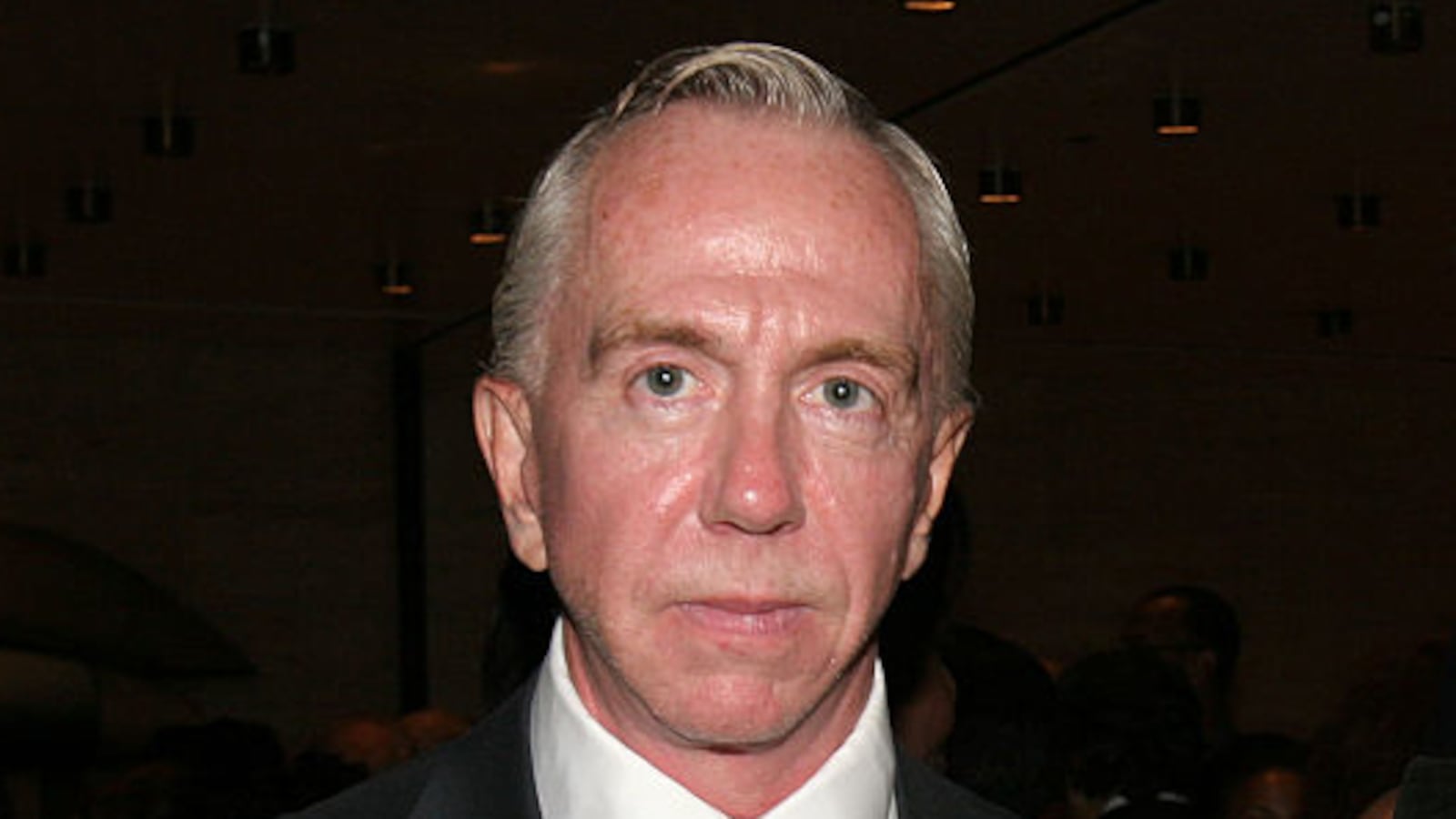 Brent Sikkema, wearing a jacket and tie, stares forward.