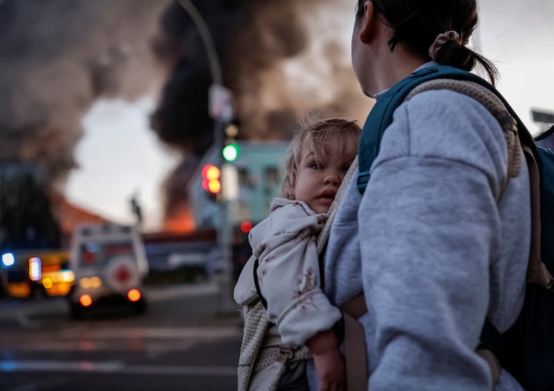 A woman with a child walks at the site of a Russian missile strike, leaving a shelter, amid Russia's attack on Ukraine, in Kyiv, Ukraine September 8, 2026.  REUTERS/Yan Dobronosov     TPX IMAGES OF THE DAY
