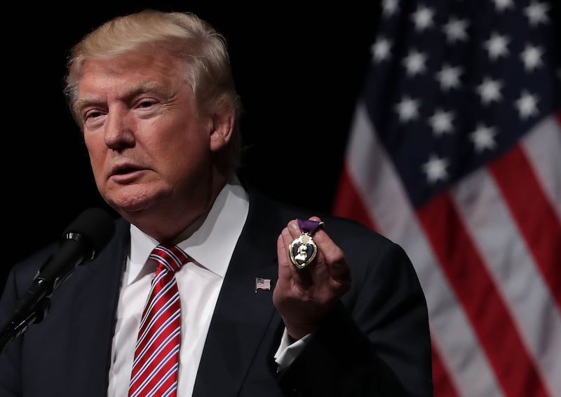 Donald Trump holds a Purple Heart, given to him by veteran Louis Dorfman, during a campaign event at Briar Woods High School August 2, 2016 in Ashburn, Virginia.