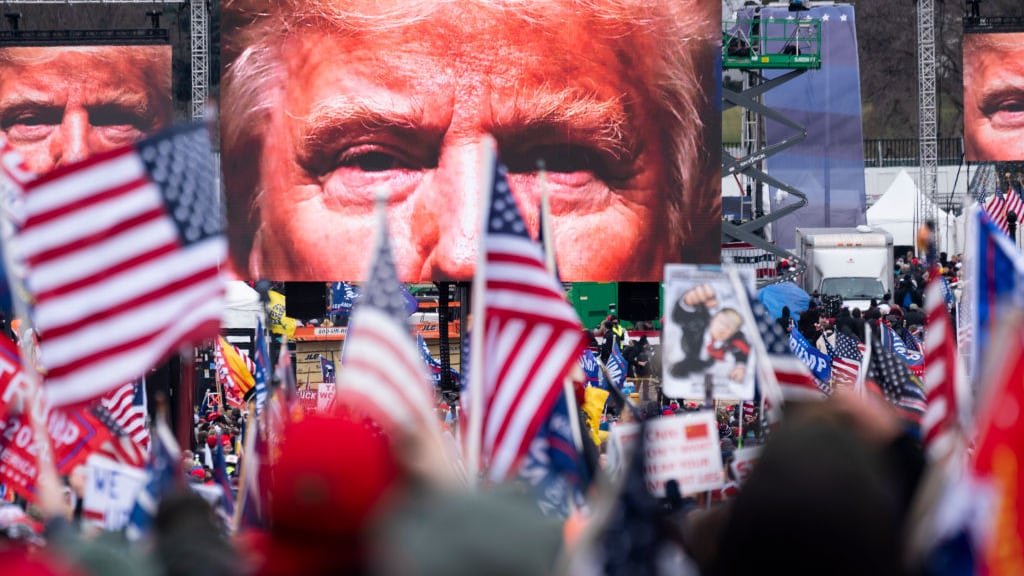 An image of President Donald Trump appears on video screens before his speech to supporters from the Ellipse at the White House in Washington on Wednesday, Jan. 6, 2021.