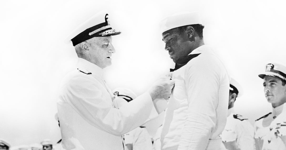 Photo: The Daily Beast Admiral Chester W. Nimitz pinning Navy Cross on Doris "Dorie" Miller at ceremony aboard the USS Enterprise, Pearl Harbor