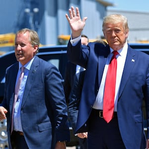 President Donald Trump waves upon arrival, alongside  Attorney General of Texas Ken Paxton (L) in Dallas, Texas, on June 11, 2020.