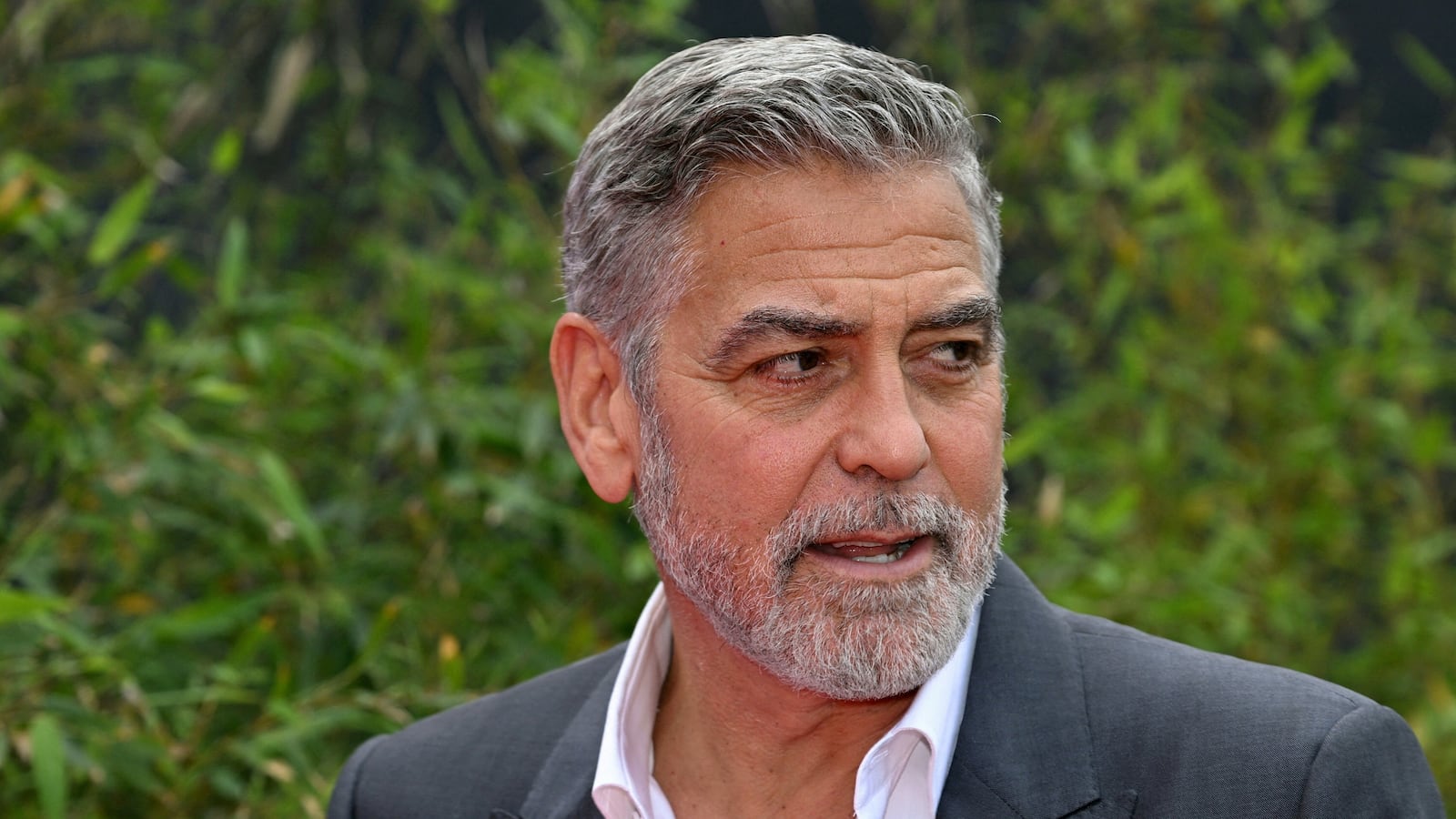 George Clooney stares to his left while at an outdoors event.