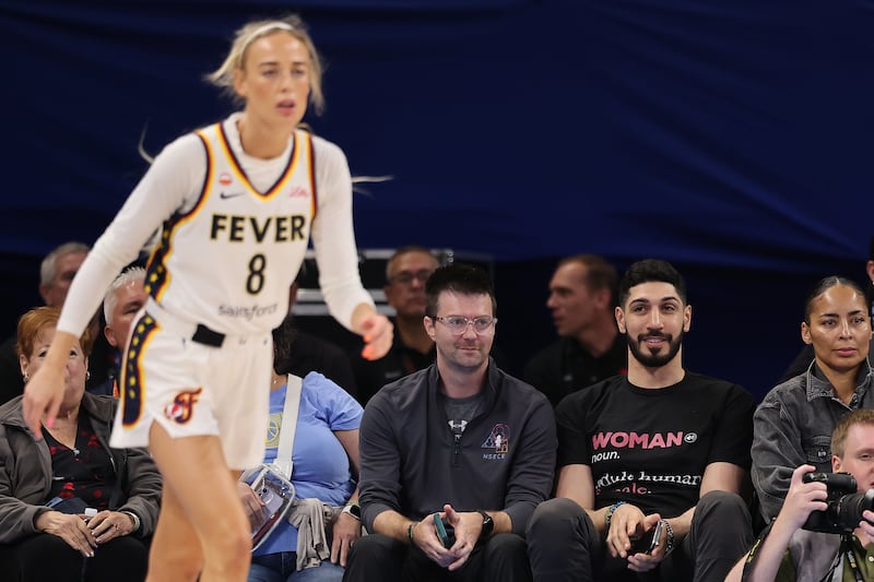 CHICAGO, ILLINOIS - AUGUST 23: Former basketball player Enes Kanter Freedom watches Sophie Cunningham #8 of the Indiana Fever courtside during the first half against the Chicago Sky at Wintrust Arena on August 23, 2026 in Chicago, Illinois.