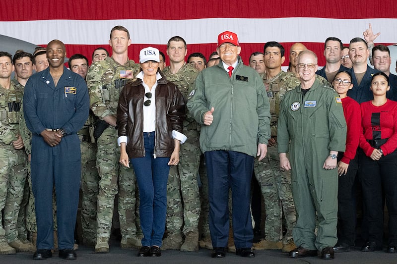 US President Donald Trump (C-R) and First Lady Melania Trump (C-L) pose as they greet sailors during a visit to the USS George H.W. Bush aircraft carrier which is out at sea near Norfolk, Virginia, October 5, 2025, as part of the US Navy's 250th anniversary celebration, "America's Navy 250: Titans of the Sea - A Salute to the Fleet".