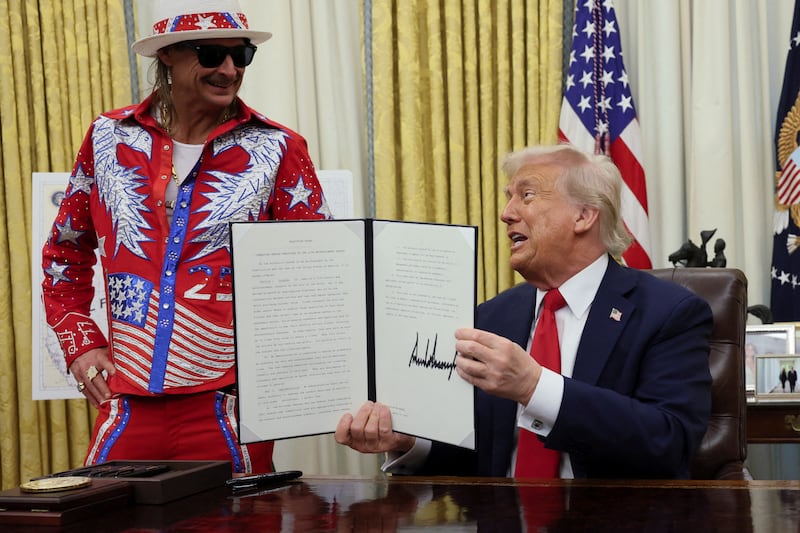 U.S. President Donald Trump holds an executive order related to the U.S. live entertainment ticketing industry, next to Kid Rock, in the Oval Office at the White House in Washington, D.C., March 31, 2025.   REUTERS/Leah Millis     TPX IMAGES OF THE DAY