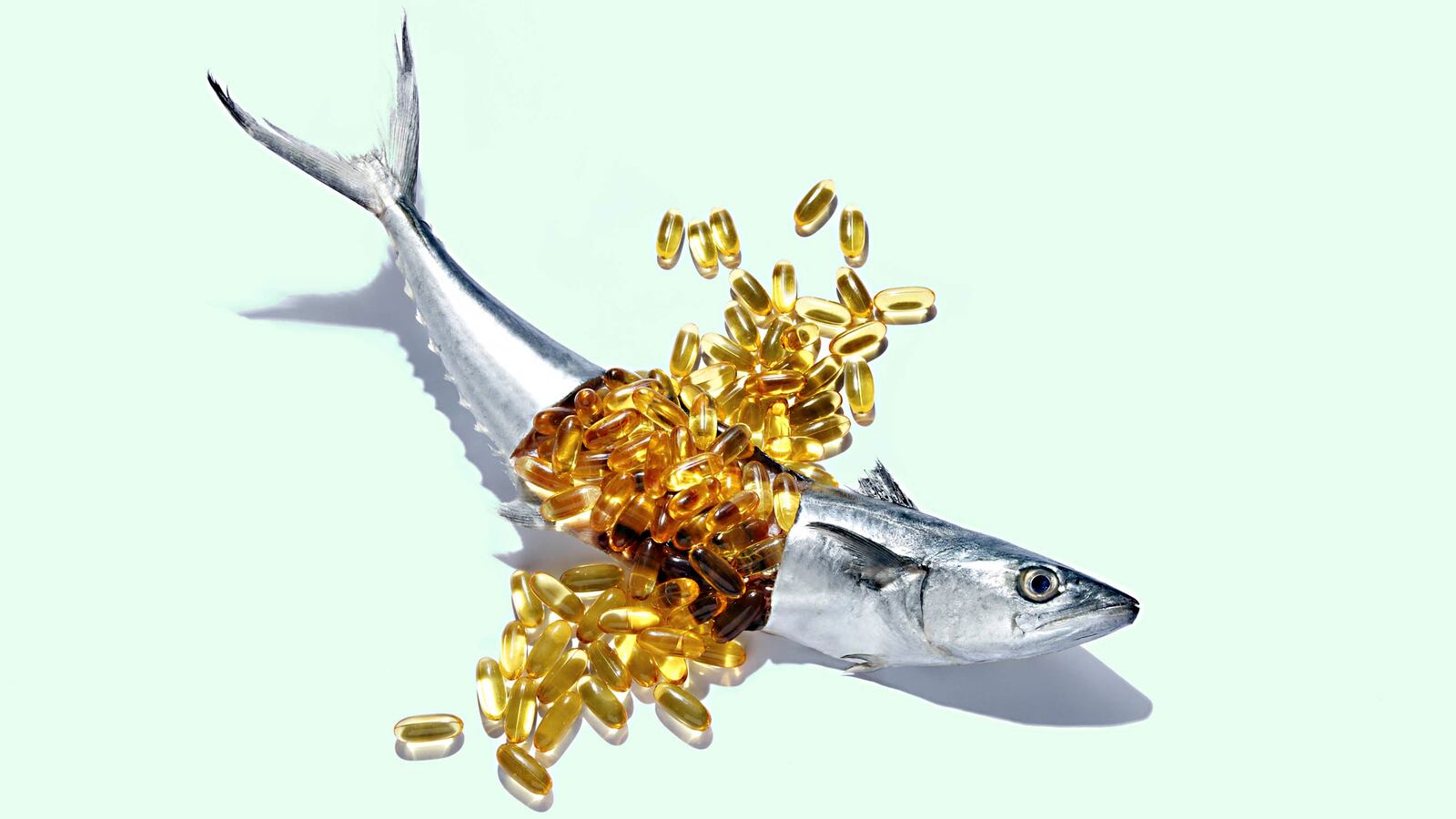 image of thin silver fish broken in half with overflow of yellow pills from stomach oil amarin corp vascepa fda heart disease stroke attack