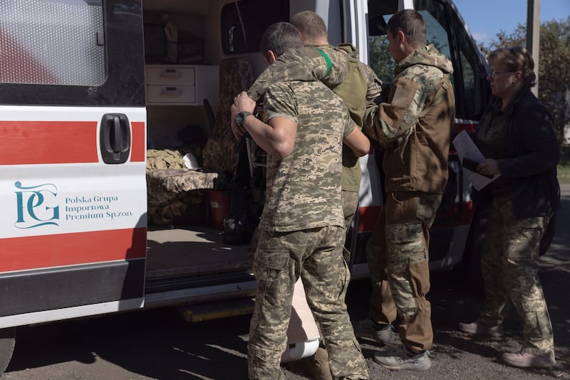 Soldiers help a wounded comrade into an ambulance on September 14, 2025 in Donetsk Oblast, Ukraine. Donetsk Oblast continues to be the place of most fierce battles since the beginning of the full-scale Russian invasion.