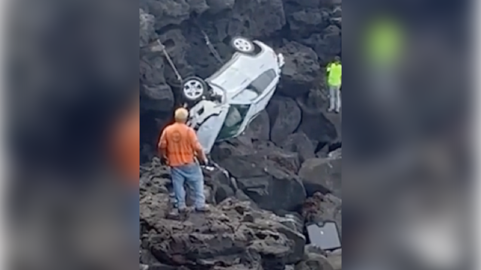 A Jeep sits atop rocks after plunging from a cliff.