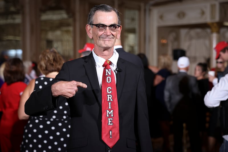 Rick Frazier, a supporter of former U.S. President Donald Trump, points to his tie while awaiting the start of an event hosted by Trump at Mar-a-Lago April 4, 2023 in West Palm Beach, Florida.
