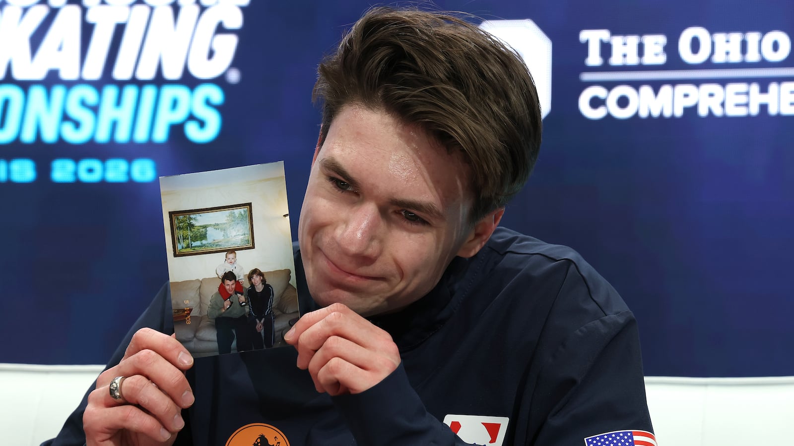 ST LOUIS, MISSOURI - JANUARY 10: Maxim Naumov holds a photograph of his parents in the kiss & cry after competing in the Championship Men Free Skating during the 2026 United States Figure Skating Championships at Enterprise Center on January 10, 2026 in St Louis, Missouri. (Photo by Jamie Squire/Getty Images)