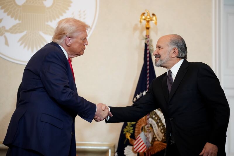 President Donald Trump shakes hands with Secretary of Commerce Howard Lutnick during a meeting with Japanese business leaders.