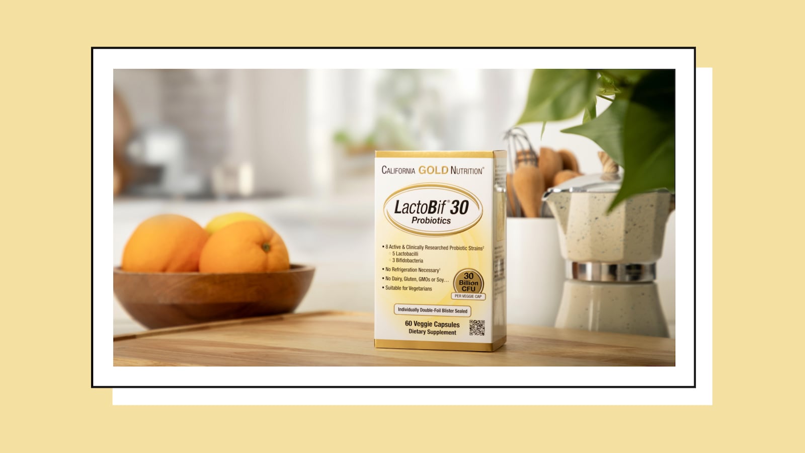 California Gold Nutrition LactoBif 30 probiotics box on a kitchen counter with oranges in a bowl and cooking utensils in the background.