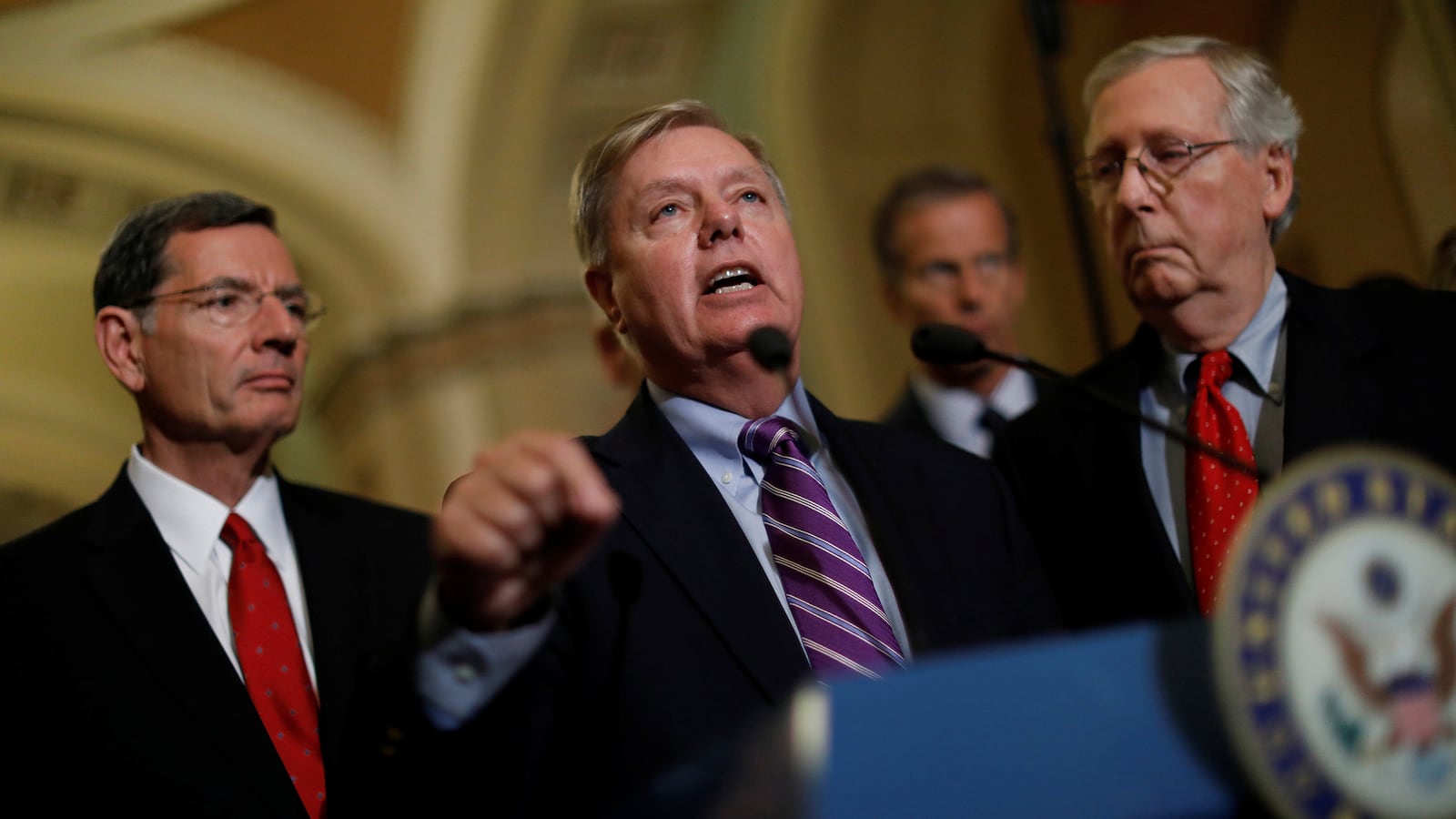 Sen. Lindsey Graham (R-SC), accompanied by Sen. John Barrasso (R-WY), and Senate Majority Leader Mitch McConnell, speaks with reporters following the party luncheons on Capitol Hill in Washington, U.S., September 19, 2017.