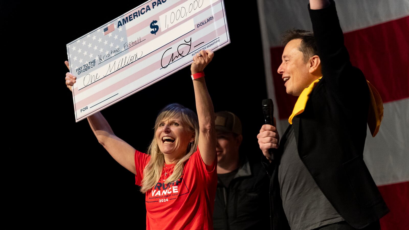 Elon Musk awards Kristine Fishell with a $1 million vanity check during a town hall in Pittsburgh, Pennsylvania.
