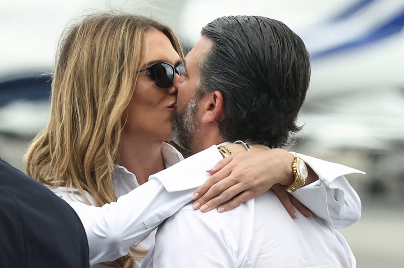 U.S. President Donald Trump's son Donald Trump Jr kisses his partner Bettina Anderson as they wait for the arrival of U.S. President Donald Trump at Teterboro Airport in Teterboro, New Jersey, U.S., July 13, 2025. REUTERS/Kevin Lamarque