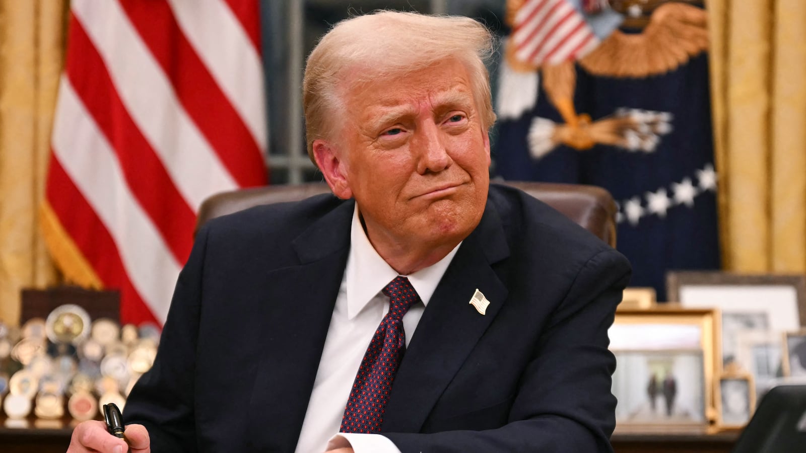 US President Donald Trump signs executive orders in the Oval Office of the White House in Washington, DC, on January 20, 2025.