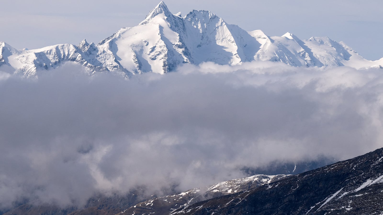 A photo taken on October 12, 2024 from the Sonnblick Observatory near Rauris, Austria, shows the Grossglockner, with 3798 metres Austria's highest mountain, in the Hohe Tauern mountain range. Experts say warmer temperatures across the Alps driven by climate change are accelerating glacier melt and thawing permafrost -- the year-round ice found at high altitude that binds together giant slabs of rock. This has increased the danger of sudden rockfalls and landslides, damaging paths and adding stress to the mountains' often-ageing huts. Austria's Alpine clubs are currently closing up to four huts a year as they have become unsafe or too costly to be maintained. (Photo by KERSTIN JOENSSON / AFP) (Photo by KERSTIN JOENSSON/AFP via Getty Images)
