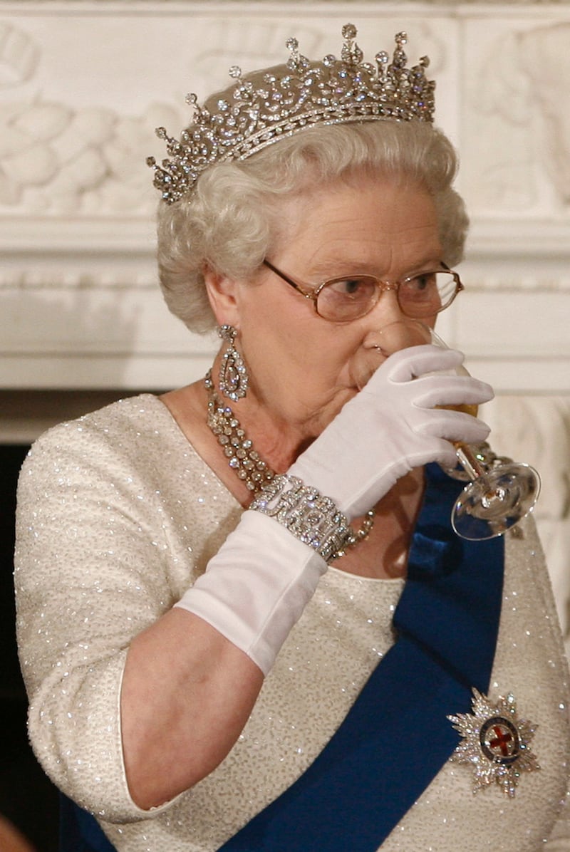 Queen Elizabeth II drinks a glass of white wine at a state dinner in the State Dining room of the White House in Washington, May 7, 2007.