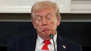 President Donald Trump reads a note during a roundtable discussion in the State Dining Room of the White House on October 08, 2025 in Washington, DC.