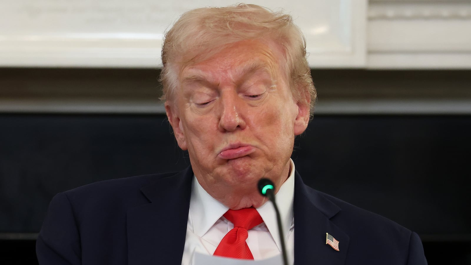 President Donald Trump reads a note during a roundtable discussion in the State Dining Room of the White House on October 08, 2025 in Washington, DC.