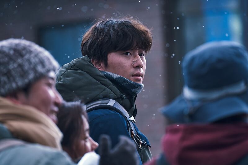 Park Seo-joon looks back through a crowd in 'Concrete Utopia'