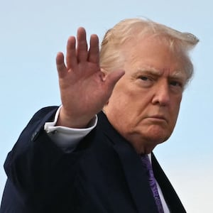 TOPSHOT - US President Donald Trump waves while boarding Air Force One at Palm Beach International Airport on November 30, 2025, on his way back to Washington, DC. President Trump and First Lady Melania Trump spent the Thanksgiving holiday at his Mar-a-Lago residence. (Photo by Jim WATSON / AFP via Getty Images)