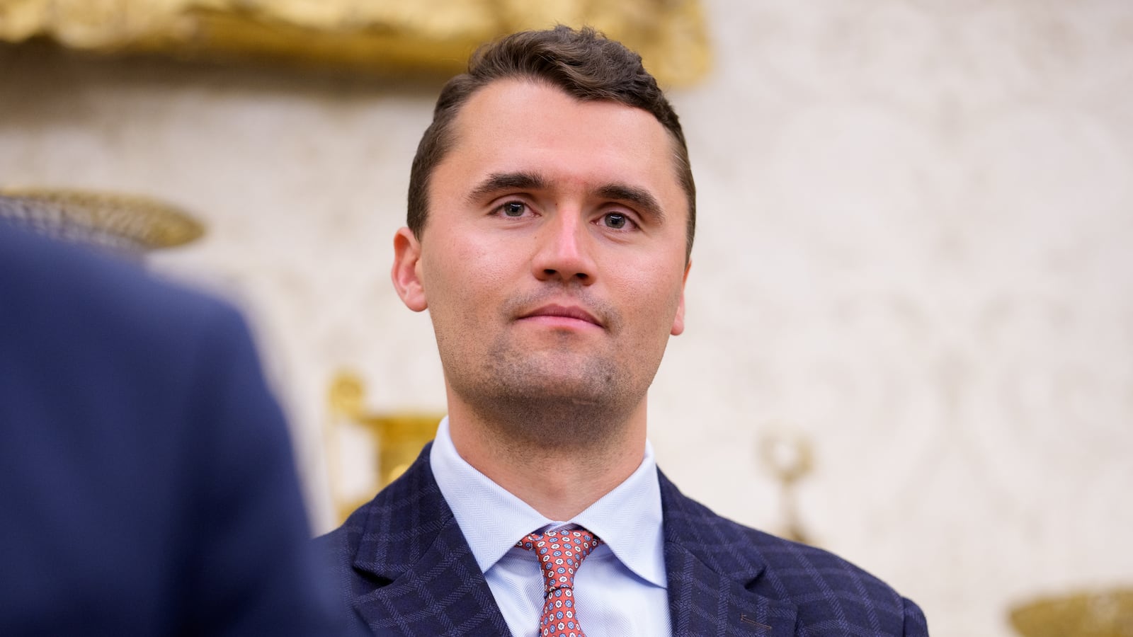 WASHINGTON, DC - MAY 28: Turning Point USA co-founder Charlie Kirk stands in the back of the room as U.S. President Donald Trump speaks during a swearing in ceremony for interim U.S. Attorney for Washington, D.C. Jeanine Pirro in the Oval Office of the White House on May 28, 2025 in Washington, DC. Trump has announced Pirro, a former Fox News personality, judge, prosecutor, and politician, after losing support in the Senate for his first choice, Ed Martin, over his views on the January 6, 2021 attack on the U.S. Capitol.