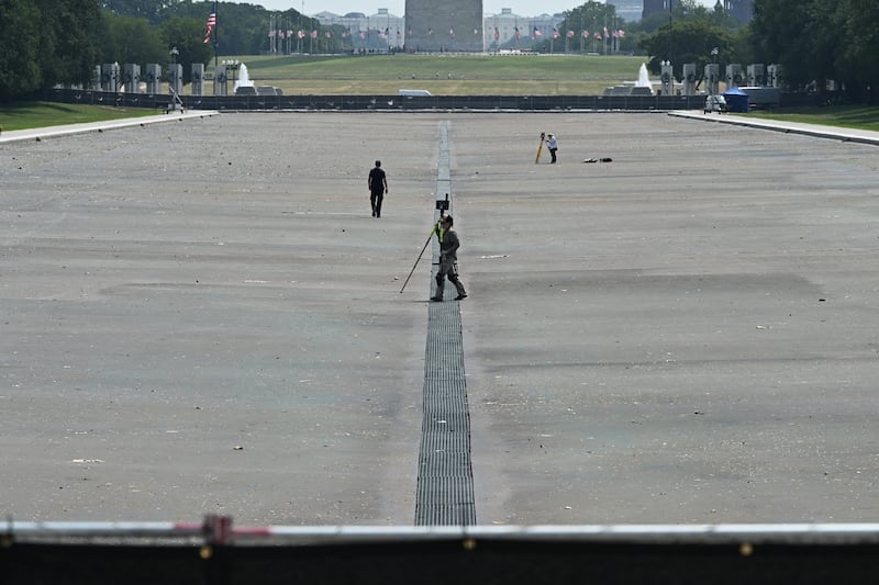 Surveyors work at the Lincoln Memorial Reflecting Pool on the National Mall in Washington, DC on July 15, 2026. US President Donald Trump said, on July 13, the newly renovated Reflecting Pool in Washington was drained for repairs, after the project has faced a series of setbacks, including alleged vandalism. The renovation of the pool next to the US capital's Lincoln Memorial is a pet project of Trump's, but the remodel has been dogged by the growth of algae and peeling paint which the president alleges is the work of vandals. "We drained the beautiful 'Reflecting Pool' today in order to fix the scars and damage that was done by the Vandals two weeks ago," Trump wrote on his Truth Social platform late Monday, adding that they waited until after the July Fourth holiday to drain the pool.