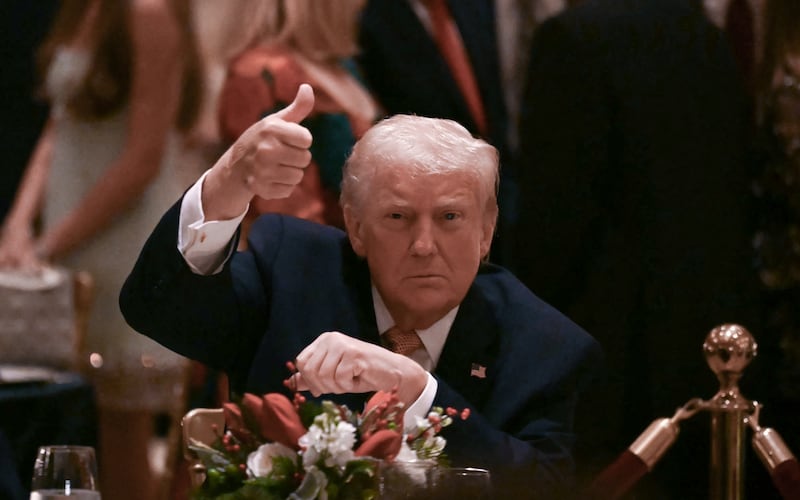 US President Donald Trump gives a thumbs up as he attends a Christmas dinner at his Mar-a-Lago resort in Palm Beach, Florida, on December 24, 2025. (Photo by ANDREW CABALLERO-REYNOLDS / AFP)