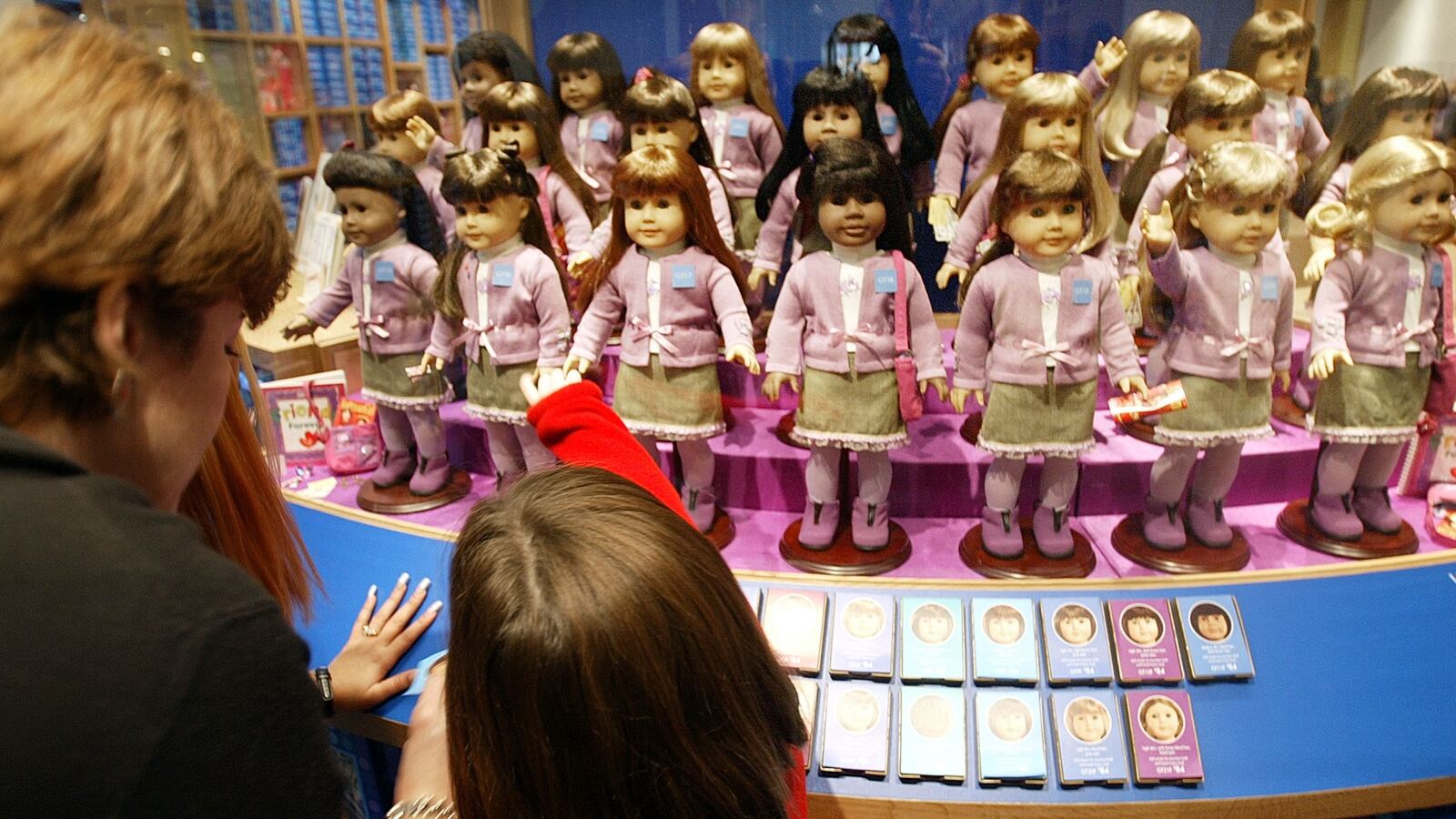 A woman and child view dolls for sale at a press preview for the opening of American Girl Place New York November 7, 2003 in New York City.