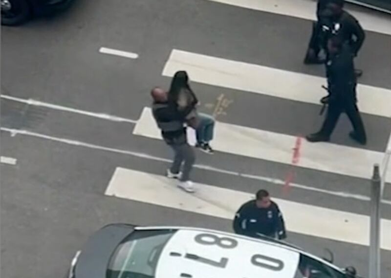 A man holding a woman surrounded by cars