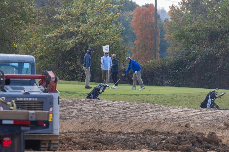 WASHINGTON, DC - OCTOBER 24: Golfers play hole six as trucks unloads debris and soil from the demolition of the White House's East Wing at East Potomac Golf Course on October 24, 2025 in Washington, DC. The demolition is part of U.S. President Donald Trump's plan to build a multimillion-dollar ballroom on the eastern side of the White House. (Photo by Tasos Katopodis/Getty Images)