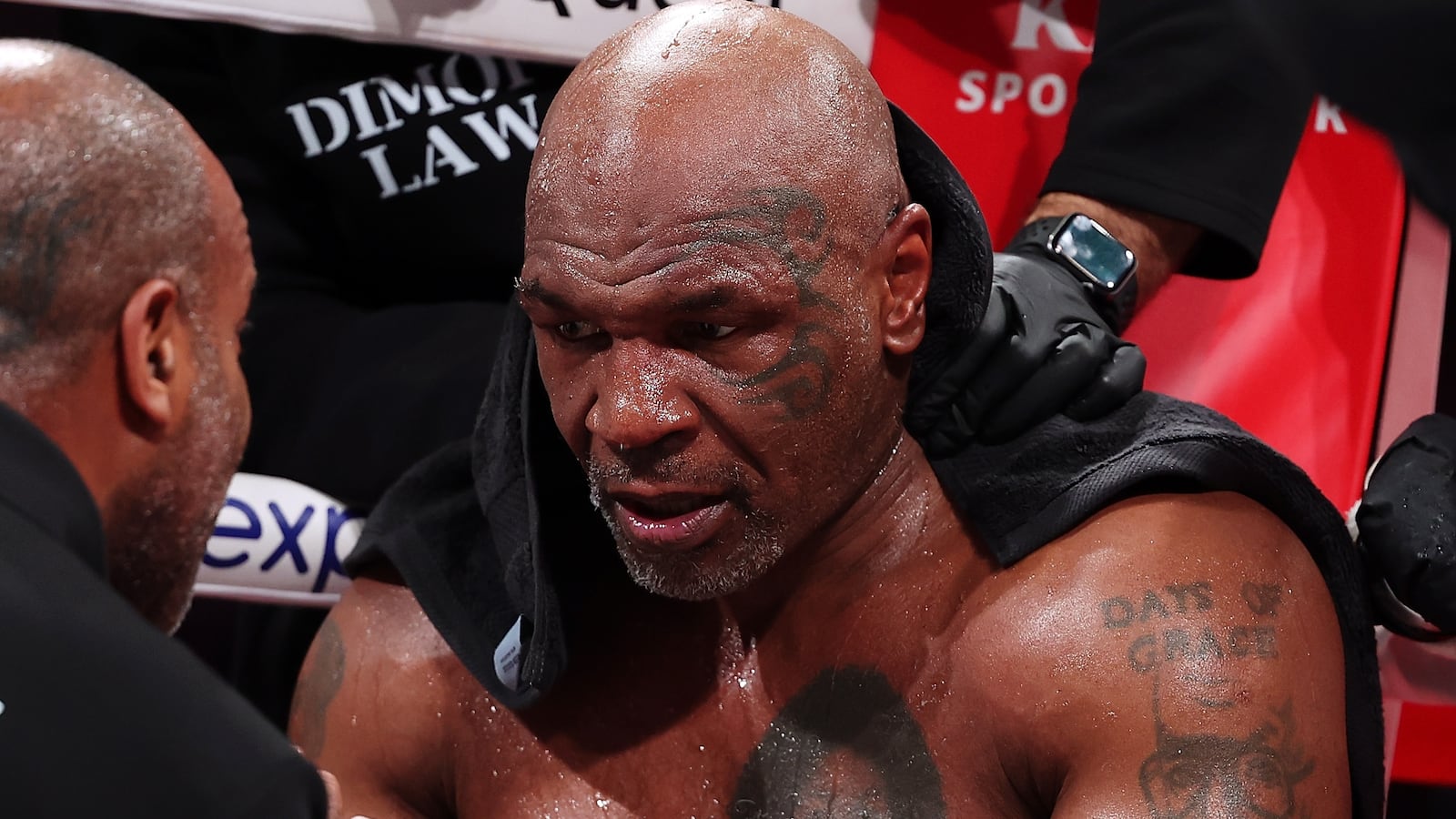 Mike Tyson sitting in a boxing ring.