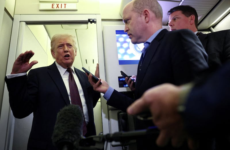 U.S. President Donald Trump speaks to reporters aboard Air Force One on a flight back to Washington March 15, 2026. REUTERS/Kevin Lamarque     TPX IMAGES OF THE DAY