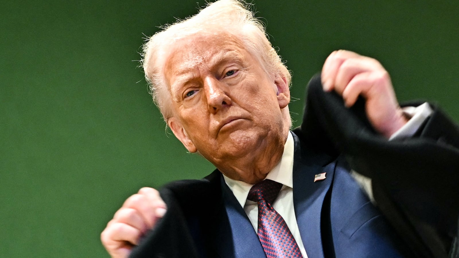 President Donald Trump adjusts his jacket as he leaves the Congress Centre during the World Economic Forum (WEF) annual meeting in Davos on January 22, 2026.