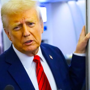 President Donald Trump, watched by White House Press Secretary Karoline Leavitt, speaks to reporters while in flight on Air Force One en route Joint Base Andrews, on January 27, 2025.