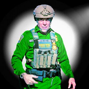 A photo illustration of Border Patrol Cmdr. Gregory Bovino in a spotlight.