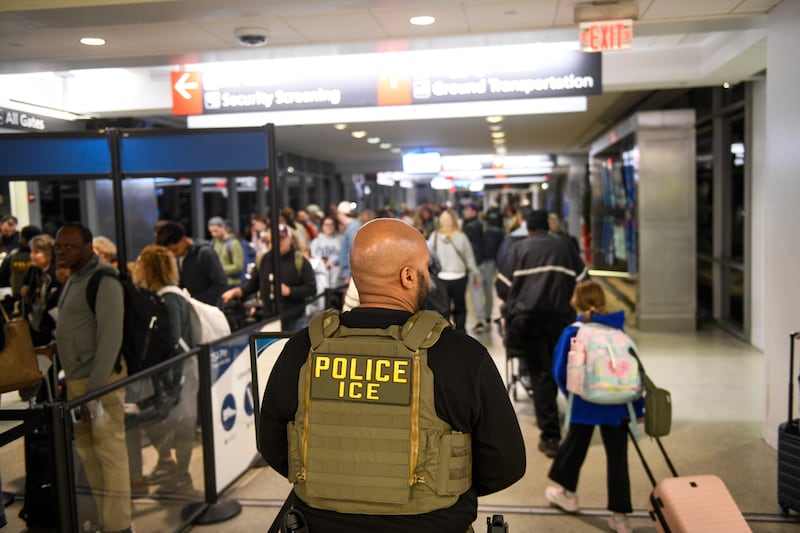 PHILADELPHIA, PENNSYLVANIA - MARCH 28: An ICE agent stands alongside a long line of travelers waiting to pass through a TSA Checkpoint at the Philadelphia International Airport on March 28, 2026 in Philadelphia, Pennsylvania. TSA agents have worked without pay for over a month during a partial government shutdown. U.S. President Donald Trump deployed ICE agents to U.S. airports on Monday, and on Friday he issued an executive order instructing DHS to pay TSA agents. (Photo by Matthew Hatcher/Getty Images)