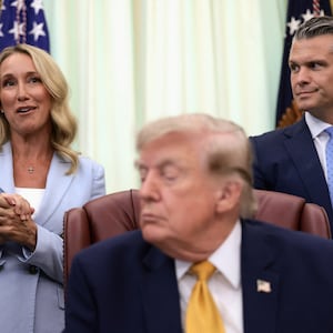 Jennifer Rauchet, wife of U.S. Secretary of Defense Pete Hegseth, speaks as U.S. President Donald Trump listens during an event to sign an executive order establishing the President's Military Spouse Commission to be chaired by Rauchet in the Oval Office at the White House in Washington, D.C., U.S., August 3, 2026. REUTERS/Evelyn Hockstein