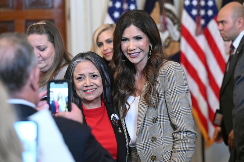 US Secretary of Homeland Security Kristi Noem poses for a photo with Marie Vega, mother of Border Patrol Agent Javier Vega Jr., during the Angel Families Remembrance Ceremony in the East Room of the White House in Washington, DC, on February 23, 2026. (Photo by SAUL LOEB / AFP via Getty Images)