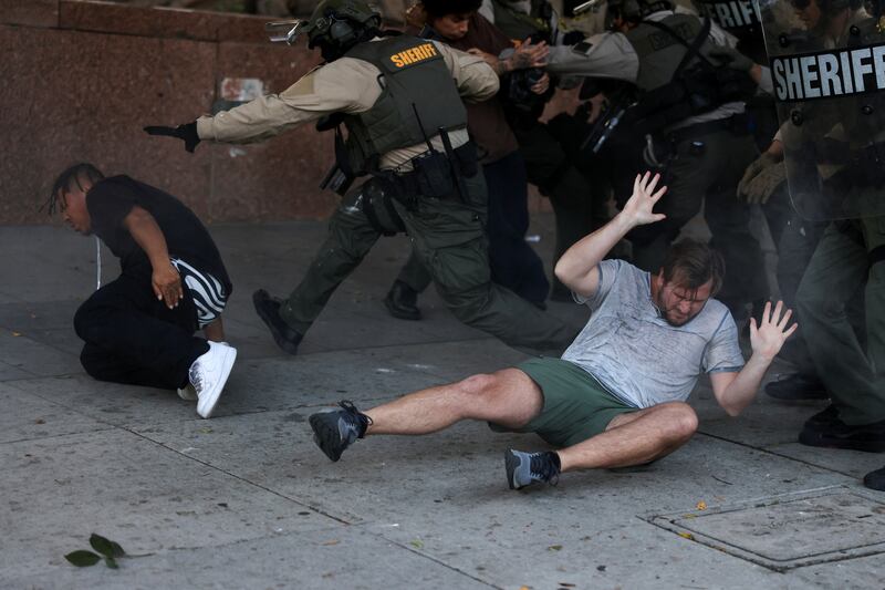 Protesters react on the ground during a clash with law enforcement officers at a protest against federal immigration sweeps, in Los Angeles, California, U.S., June 11, 2025. REUTERS/David Swanson