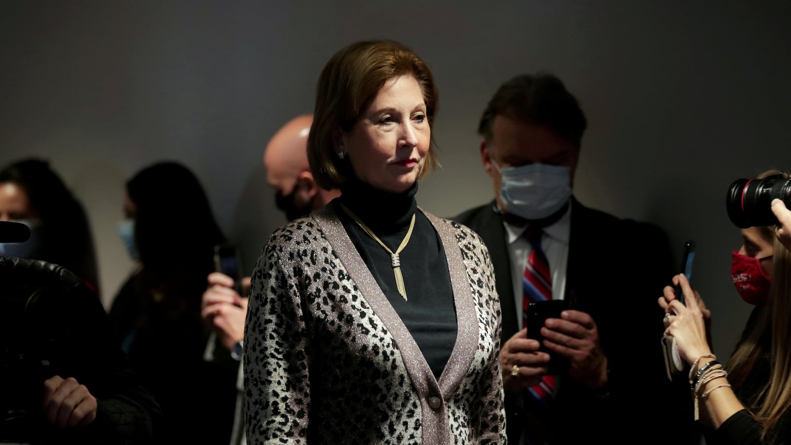 Sidney Powell listens to reporters during a news conference.