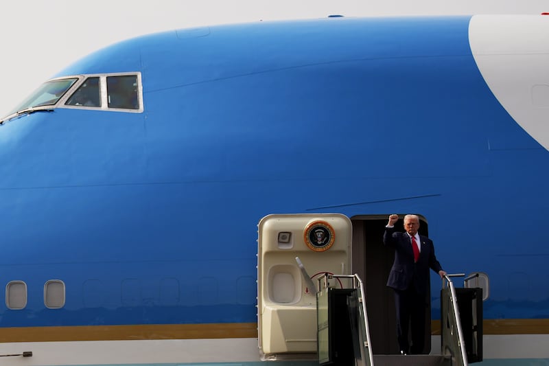U.S. President Donald Trump raises a fist as he boards Air Force One following a bilateral meeting with Chinese President Xi Jinping on October 30, 2025 in Gyeongju, South Korea.