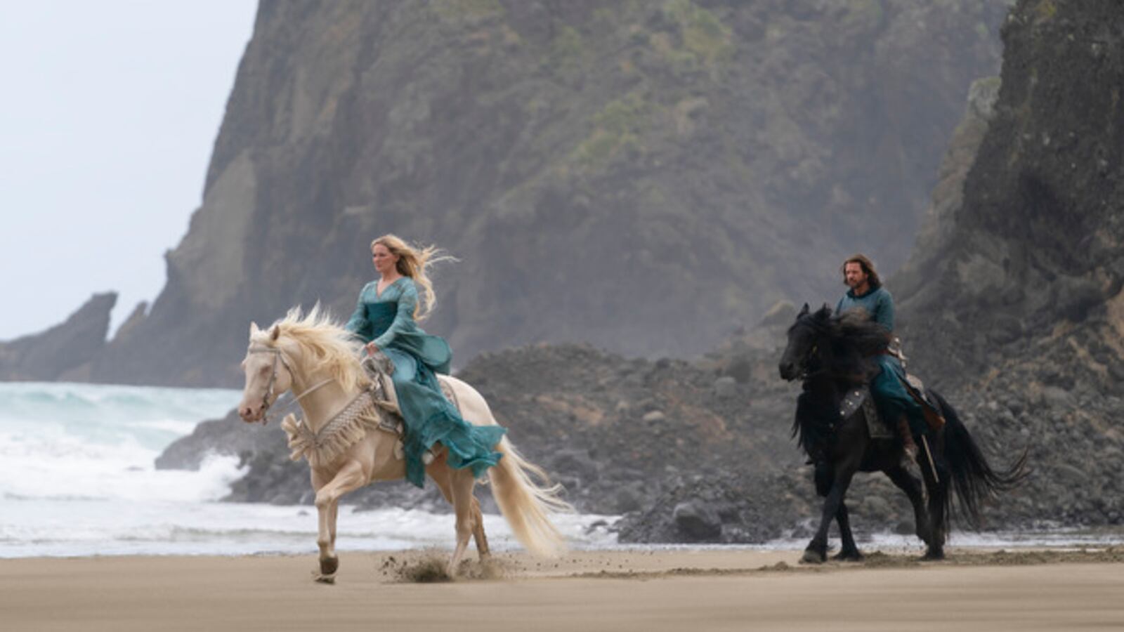 Two people ride horses in a promotional still from The Lord of the Rings: The Rings of Power